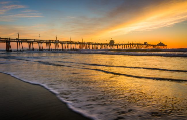Waves in the Pacific Ocean and the fishing pier at sunset in Imperial Beach California.